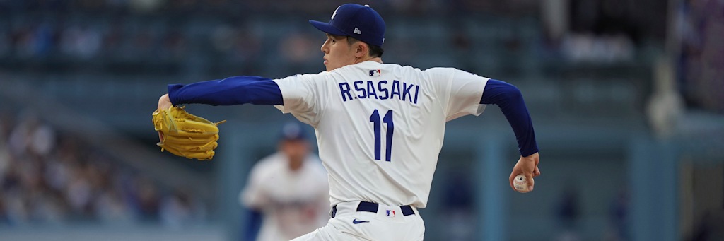 Roki Sasaki of the Los Angeles Dodgers mid-delivery in his white number 11 home uniform, the starter carrying a 5.33 ERA and 19 home runs allowed into Yankee Stadium on the July 17 second-half opener board